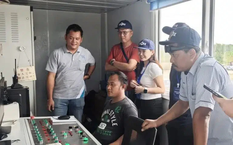 watching concrete batching plant operation on-site with customers and engineers inspecting equipment