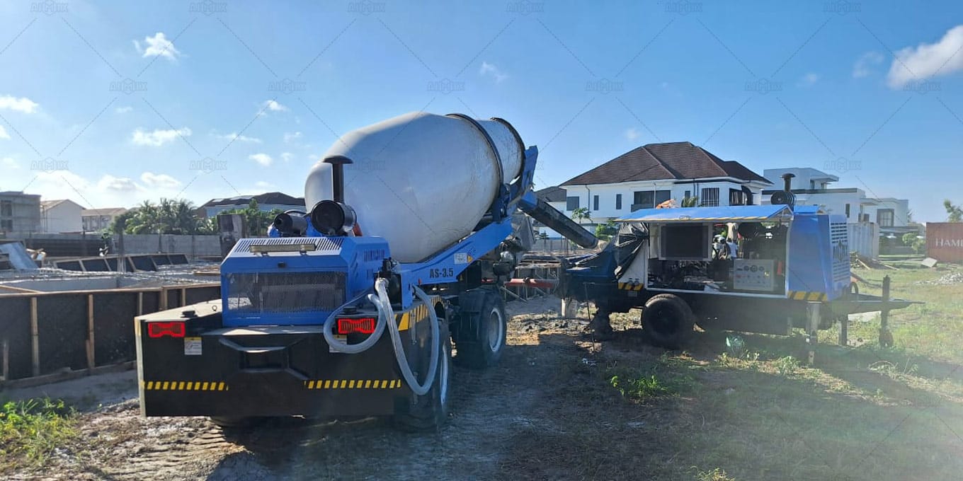 AIMIX AS-3.5 self loading concrete mixer feeding concrete into an ABT40C diesel concrete pump at a Community  construction site in Lagos, Nigeria.